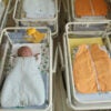 Overhead shot of a hospital nursery, empty but for one baby.